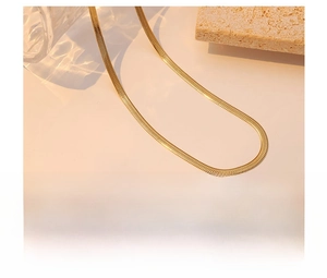 Detailed close-up of gold snake bone chain showing titanium steel and vacuum plating texture