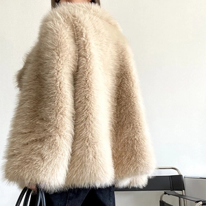 Rear view detail of high-volume beige faux fur coat with plush animal-free texture