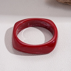 Macro shot of irregular deep red resin bangle with white marble smoke texture