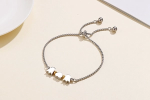 Detailed view of adjustable stainless steel bracelet with heart and petal pendants