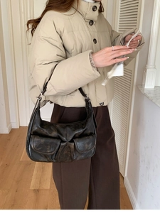 Deep brown retro leather baguette bag with dual front pockets worn by a model