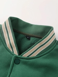 Détail du col d'un blouson teddy vert avec bord-côte rayé et doublure polaire