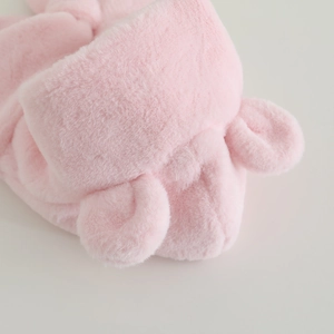 Close-up of soft pink plush fabric and cute bear ear design on the children's winter hat