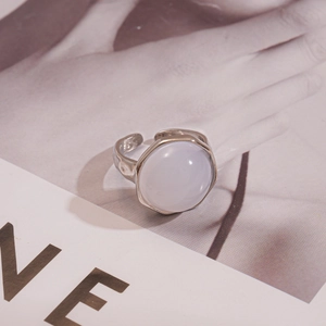 Détail de la bague en métal argenté avec pierre bleu clair sur un magazine