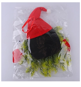 Detail of a Christmas gnome wreath featuring a red hat and green pine needles in packaging