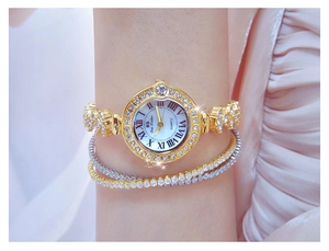 Close-up of luxury women's watch with rhinestone-studded gold chain and white Roman dial