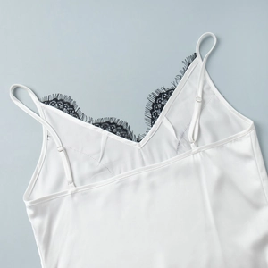 Détail du col en dentelle et des bretelles réglables sur ce caraco en satin blanc