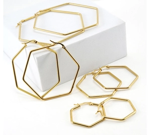 Set of four varying sized golden hexagonal hoop earrings in minimalist geometric style