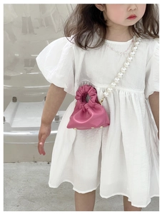 Detail of pink cloud-shaped girl's crossbody bag with elegant pearl chain strap