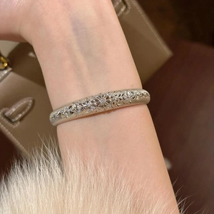 Detailed view of vintage silver hollow flower bracelet with cubic zirconia on wrist