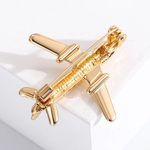 Detail of gold airplane brooch back showing secure safety pin clasp and metal texture