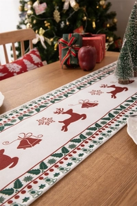 Close-up of a festive Christmas table runner with red reindeer and green holly patterns