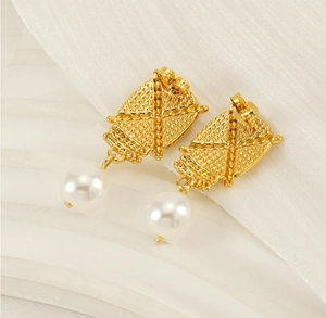 Macro detail of gold-plated woven texture shield earrings with white drop pearls