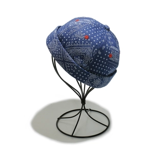 Detail of navy blue bandana docker hat with white paisley print and red ventilation eyelet