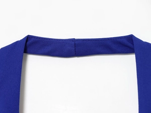 Détail du tissu en sergé bleu montrant des coutures précises sur une robe dos nu
