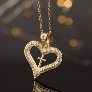 Elegante ciondolo a cuore dorato con croce di cristallo su una collana a catena fine