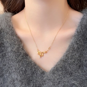 Dettaglio della collana serpente dorata con diamante indossata sulla clavicola