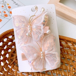 Dettaglio di fermagli per capelli a farfalla in rete rosa con paillettes e perle finte