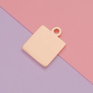 Detailed view of polished rose gold square pendant with top ring on pink background
