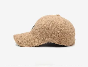 Detail view of beige teddy fleece baseball cap with textured curly wool and logo patch
