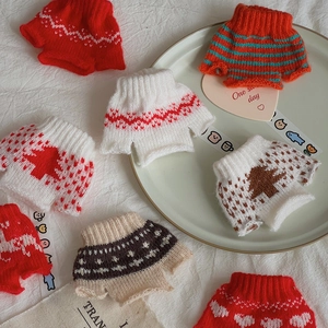Macro shot of assorted mini knitted sweaters with festive patterns for DIY decor