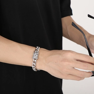 Close-up of polished silver Cuban chain bracelet with crystal encrusted clasp on wrist