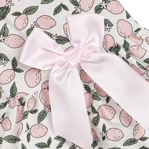Close-up of pink satin bow and lemon print on pet clothes with neat sewing pleats
