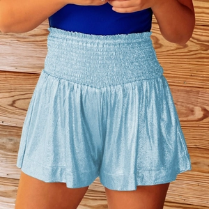 Close-up of light blue metallic shorts featuring a wide smocked high-waisted elastic band