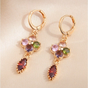Elegant gold drop earrings with colorful zircon floral design on beige silk fabric