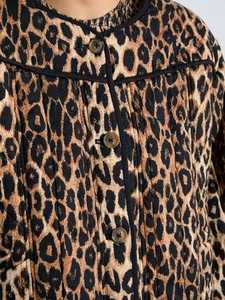 Close-up of leopard print quilted jacket featuring round neck and button closure details