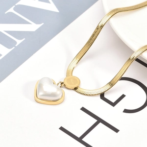 Golden snake chain necklace with white heart pendant and LOVE engraved round tag on white base