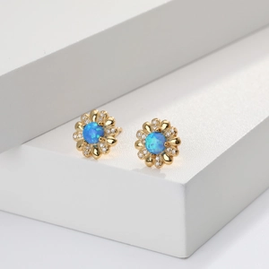 Detailansicht der goldenen Blumenohrringe mit blauem Opal und Zirkonia Steinen
