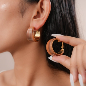 Detail view of tortoiseshell resin C-shape earring with gold metal lining on earlobe