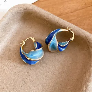 Minimalist gold twisted hoop earrings featuring blue gradient enamel and marble texture