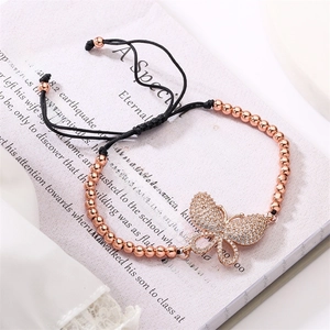 Detail of rose gold butterfly charm with inlaid zircons and black adjustable drawstring