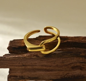 Macro shot of minimalist gold double-layer cross ring on a rustic wooden stand