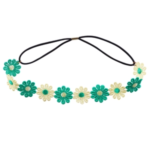 Detail of embroidered daisy flowers in green and cream on a black elastic headband