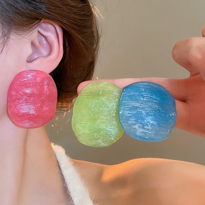 Detail of pink, green and blue resin hoop earrings with textured brushed surface
