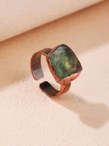 Dettaglio macro del cristallo di fluorite verde grezza con fascia testurizzata in bronzo