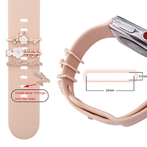 Detail of rose gold and white enamel charms on a 22mm silicone watch band