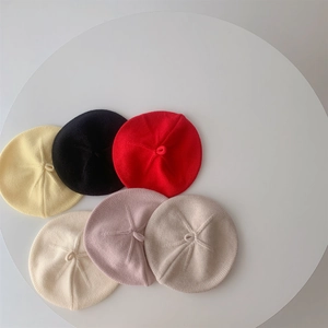 Flat lay view of knit baby berets in yellow black red beige pink and khaki colors