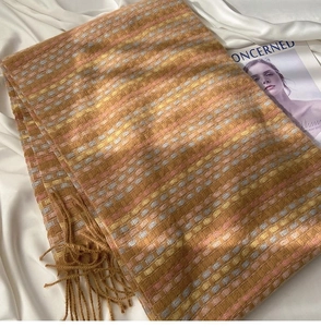 Detail of rainbow plaid scarf with soft fringe and thick warm knit texture