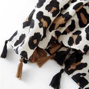 Close-up of leopard print scarf featuring breathable cotton linen fabric and fringe tassels