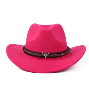 Close-up of hot pink cowboy hat featuring brown leather band and silver bull skull detail