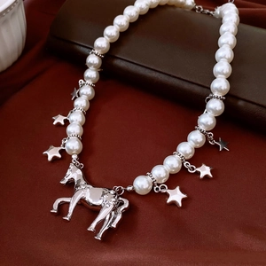 Gros plan détaillé d'un collier de perles avec pendentif cheval argenté sur cuir