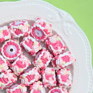 Colorful resin cake-shaped beads for DIY jewelry making on white embossed plate