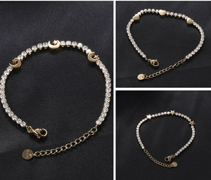 Detail of gold stainless steel bracelets with moon, heart and star zircon charms