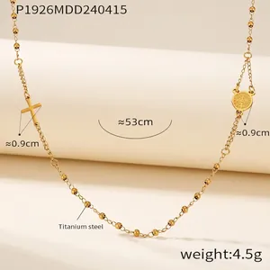 Detailed titanium steel cross necklace with a round medallion on a gold beaded chain