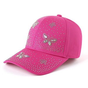Détail de la casquette rose ornée de strass brillants avec motifs de papillon et fleurs