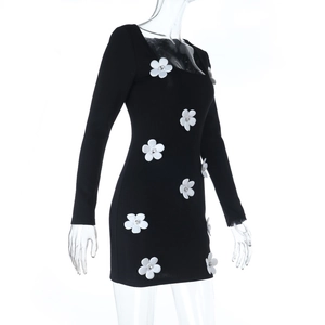Vue latérale d'une mini-robe noire moulante avec appliques florales 3D blanches et manches